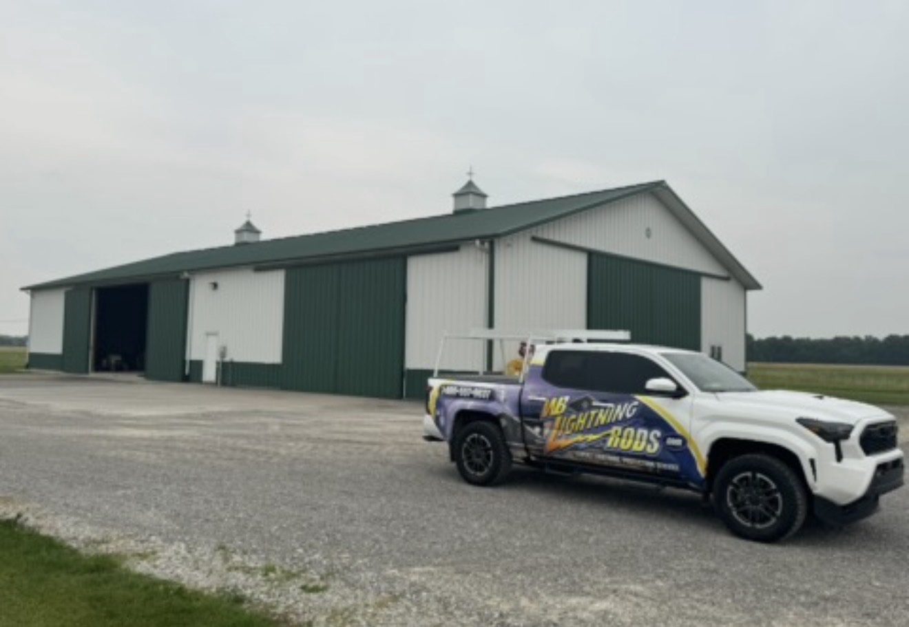 Green metal pole barn on a working farm fitted with lightning protection